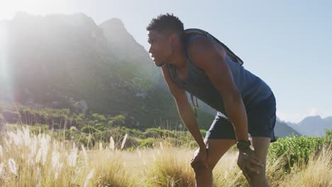 Hombre-Afroamericano-Haciendo-Ejercicio-Al-Aire-Libre-Apoyado-En-Sus-Rodillas-En-El-Campo-En-Una-Montaña