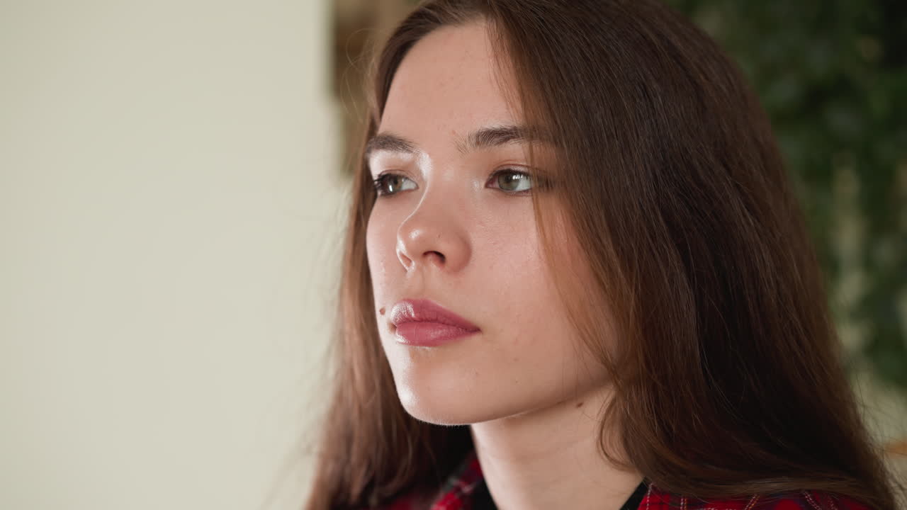 mujer bonita con maquillaje ligero en casa de primer plano. joven atractiva con cabello castaño suelto posa para la cámara en el estudio. hermosa modelo femenina