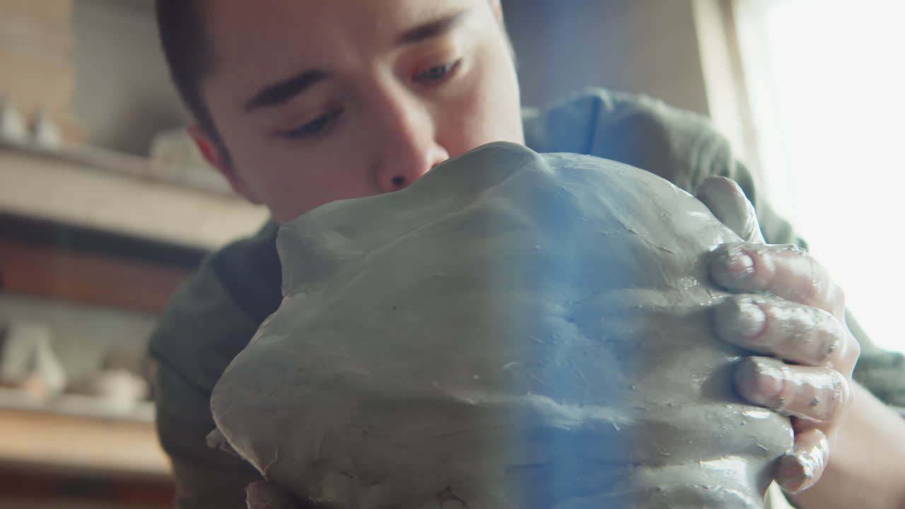 젊은 여성 예술가 가 점토 머리 를 조각 하고 있다