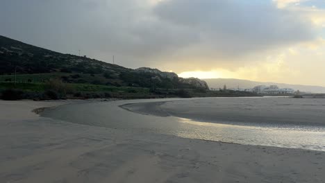 Tranquil-beachscape-where-water-gently-flows-through-channels-in-the-sand,-illustrating-the-concept-of-erosion-and-nature's-transformative-processes