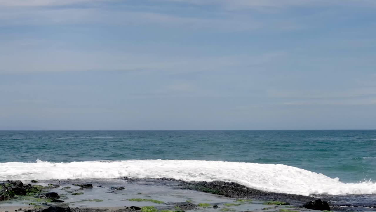 바다의 파도가 바위가 있는 해변에 부히고