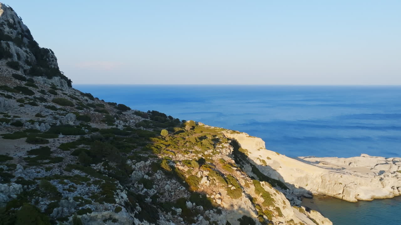 Aerial view over rocky cliffs, toward the Mediterranean sea, sunset in Rhodes