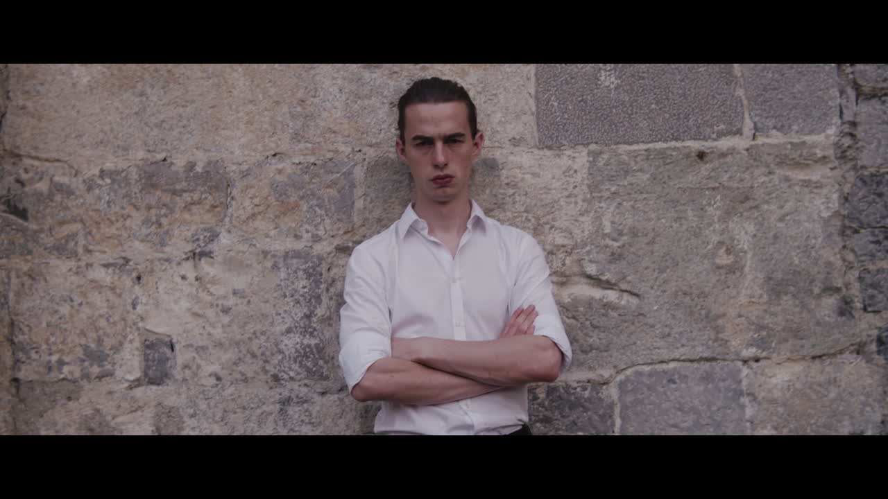 Young Man Leaning Against a Stone Wall