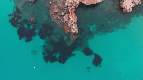 Aerial-footage-of-crystal-water-and-rocky-cliffs-on-beautifull-island