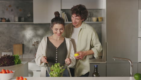 a couple preparing a fresh salad together in a modern kitchen