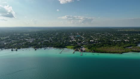 vista aérea con vistas a la ciudad de bacalar, en el soleado méxico - seguimiento, disparo de drones