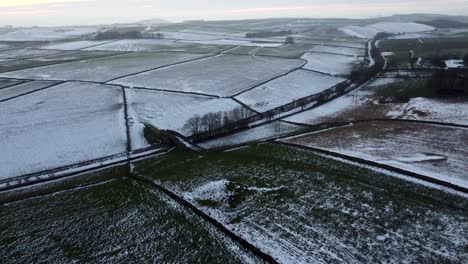 Calm-aerial-shot-of-serene-snowy-meadows-in-Peak-District,-United-Kingdom