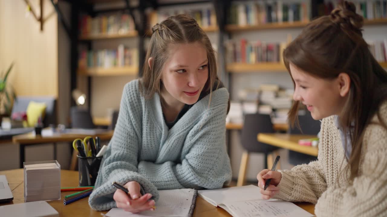 dos chicas estudiando juntas en un café