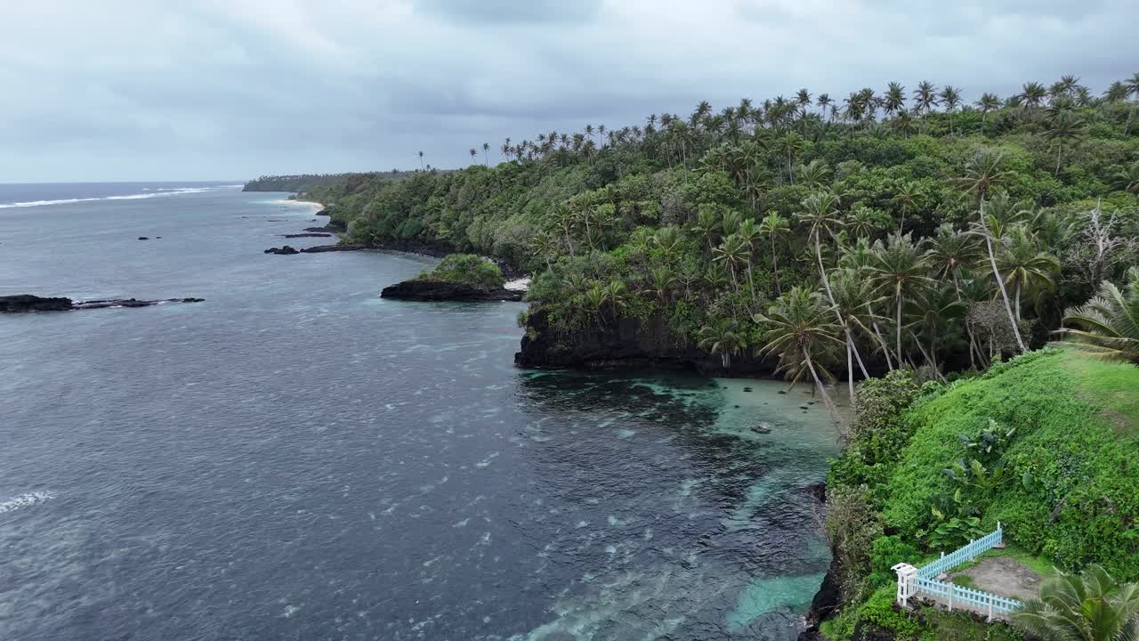 Maestosa ripresa aerea con drone delle ripide e frastagliate scogliere e delle lussureggianti colline verdi della costa samoana che si affaccia sull'immenso Oceano Pacifico