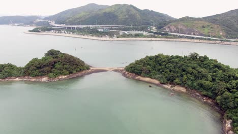 bahía de hong kong, con una franja de arena que conecta pequeñas islas naturales, vista aérea