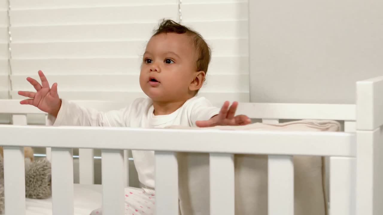 Bambino carino seduto nella sua culla