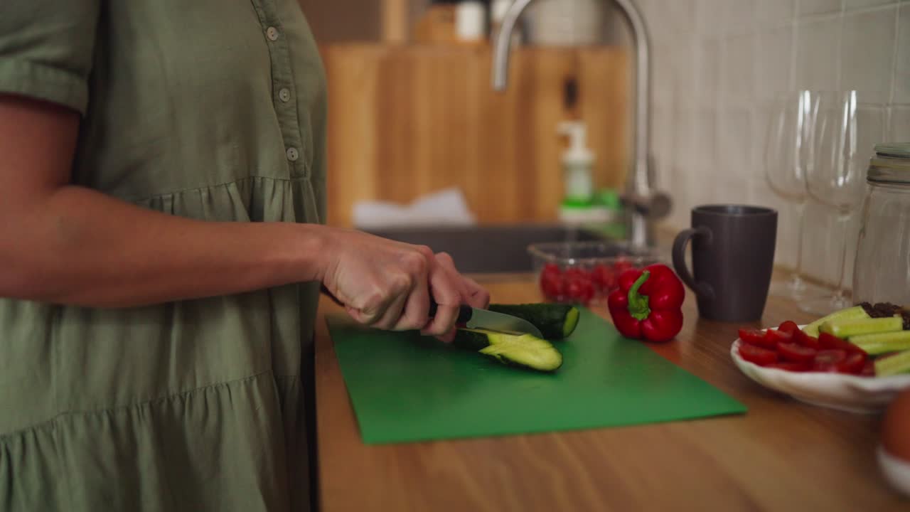 mujer cortando pepino en la cocina