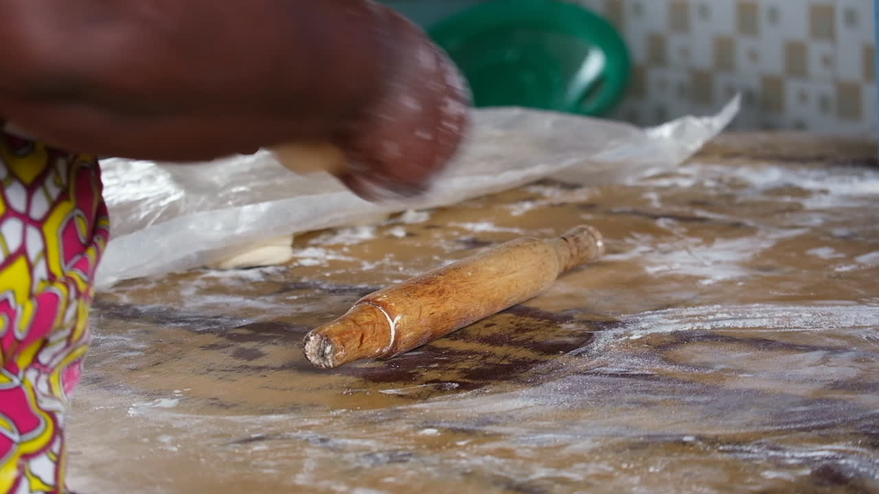 Close-up of dough being prepared on a floured table, with hands working the mixture