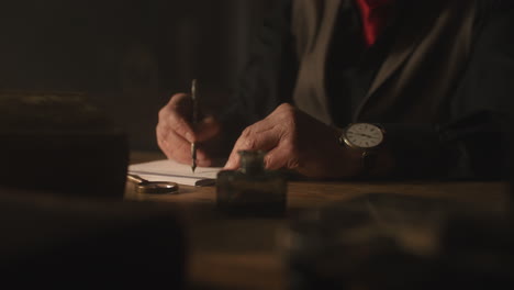 old passionate man writes a letter in his office at night