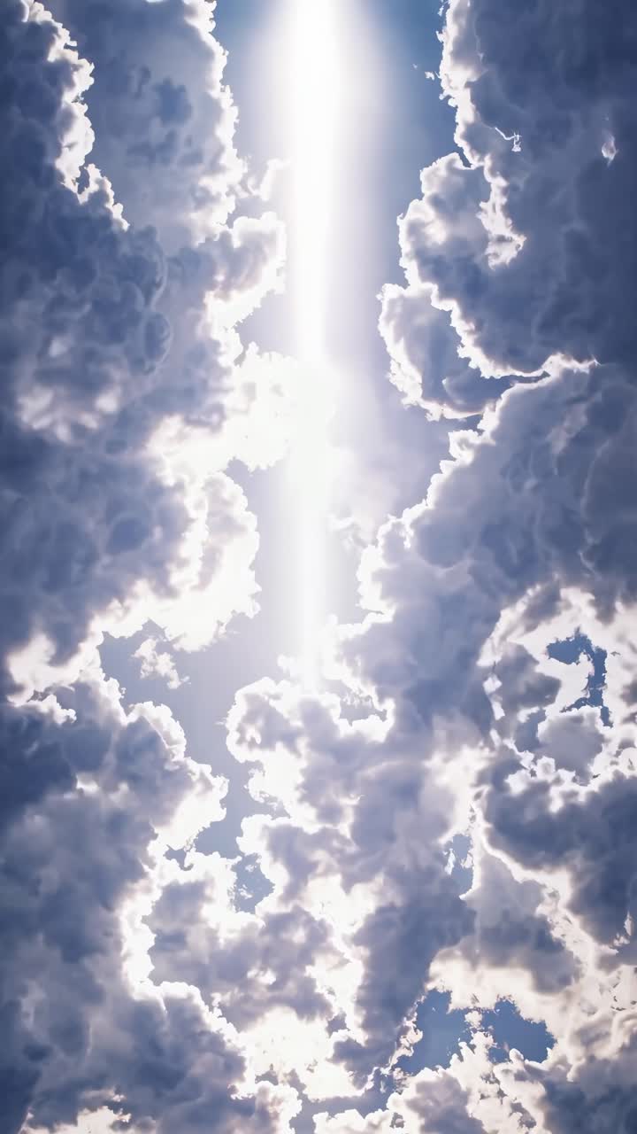 Dramatic upward angle capturing sunlight piercing through clouds, creating a heavenly, cinematic