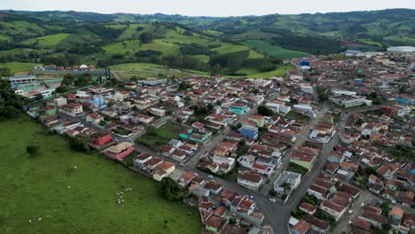 real state brazil - aerial view of a small town surrounded by mountains and green fields in brazil - bueno brandao, minas gerais