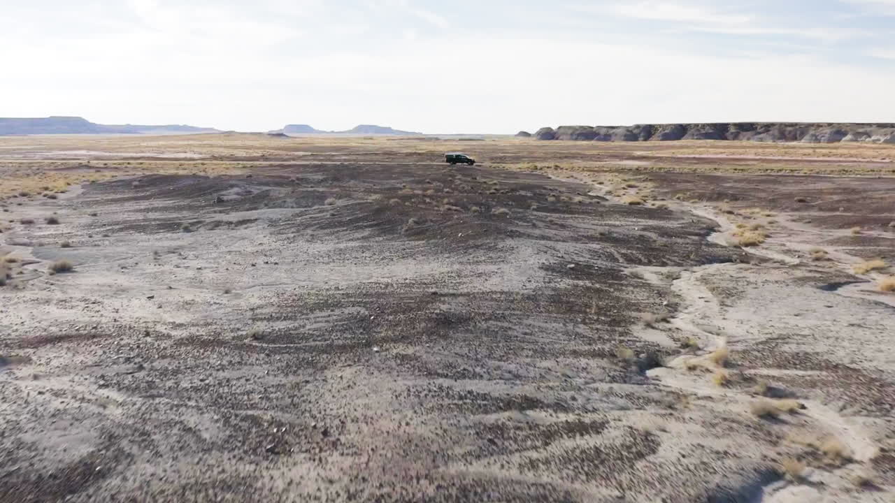 Aerial viewpoint of the arid fields with small patches of grass at Badlands in Arizona, USA
