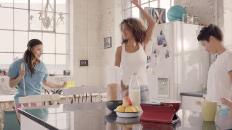 un grupo joven de amigas bailando en la cocina con pijama