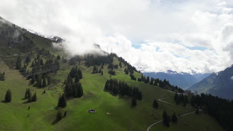 Fronalpstock-Glarus-Switzerland-aerial-green-valley-at-edge-of-mountain-just-below-clouds