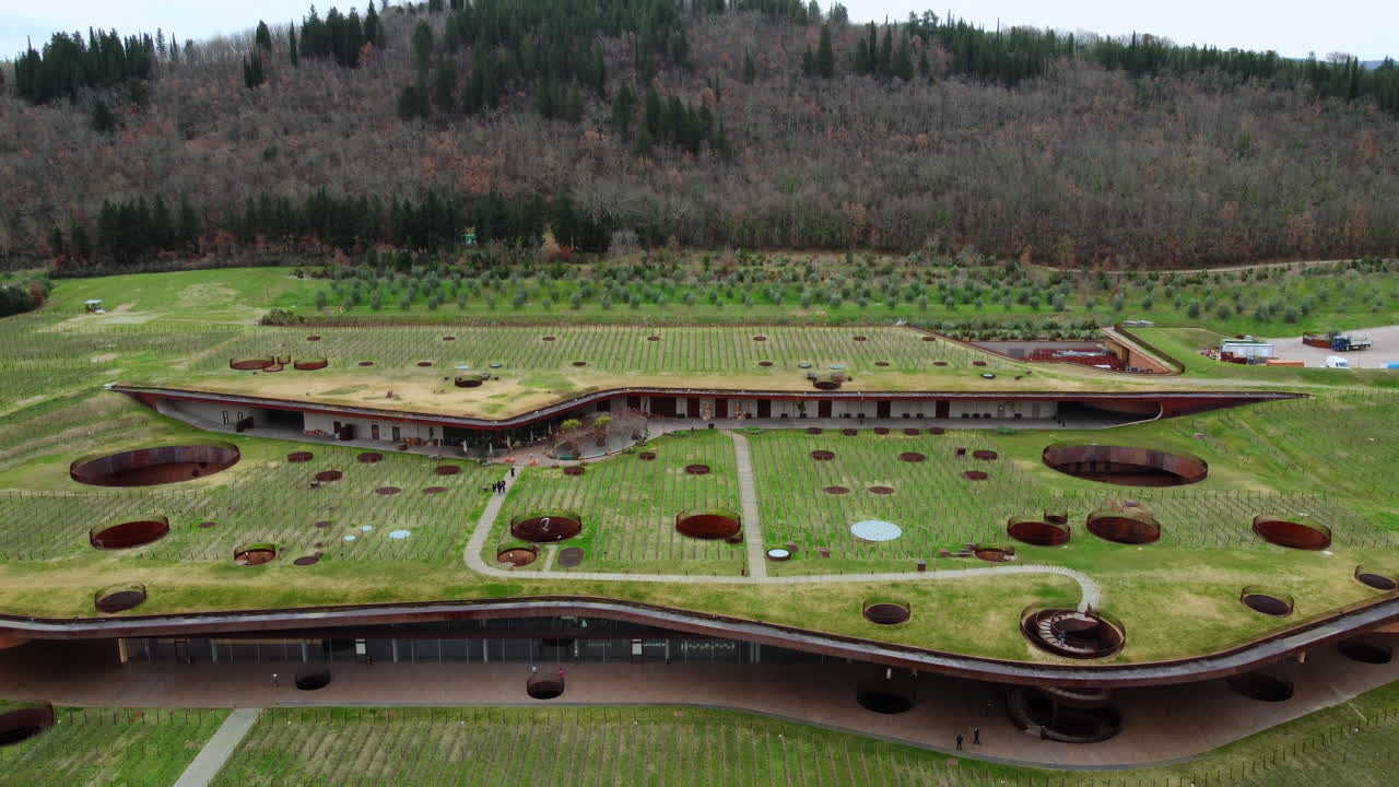 Descending shot of a Architectural Masterpiece Winery Blending with the Tuscan Landscape