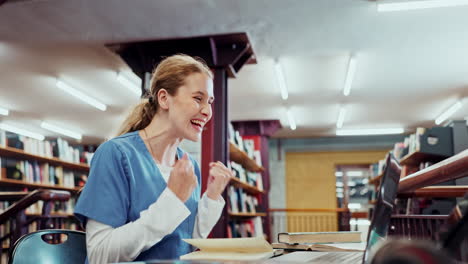 Excited medical student celebrating success in library