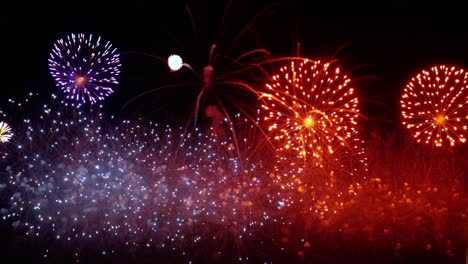 coloridos fuegos artificiales explotando en el cielo nocturno. celebraciones y eventos en colores brillantes.