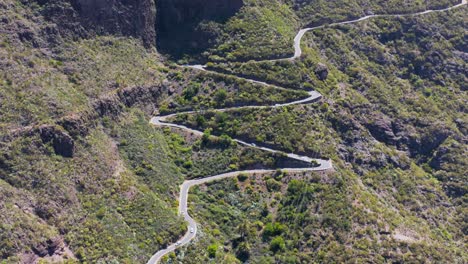 steep mountain road going up green slope on tenerife, canary island, aerial