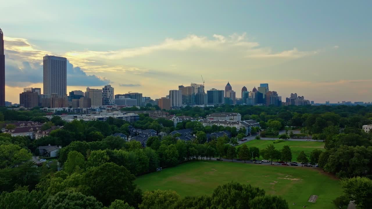 Central park neighbourhood with midtown Atlanta skyline buildings and skyscrapers in background at sunrise, Revealing drone shot