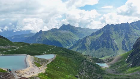 aerial - turquoise alpine water reservoirs on mountain range, austria