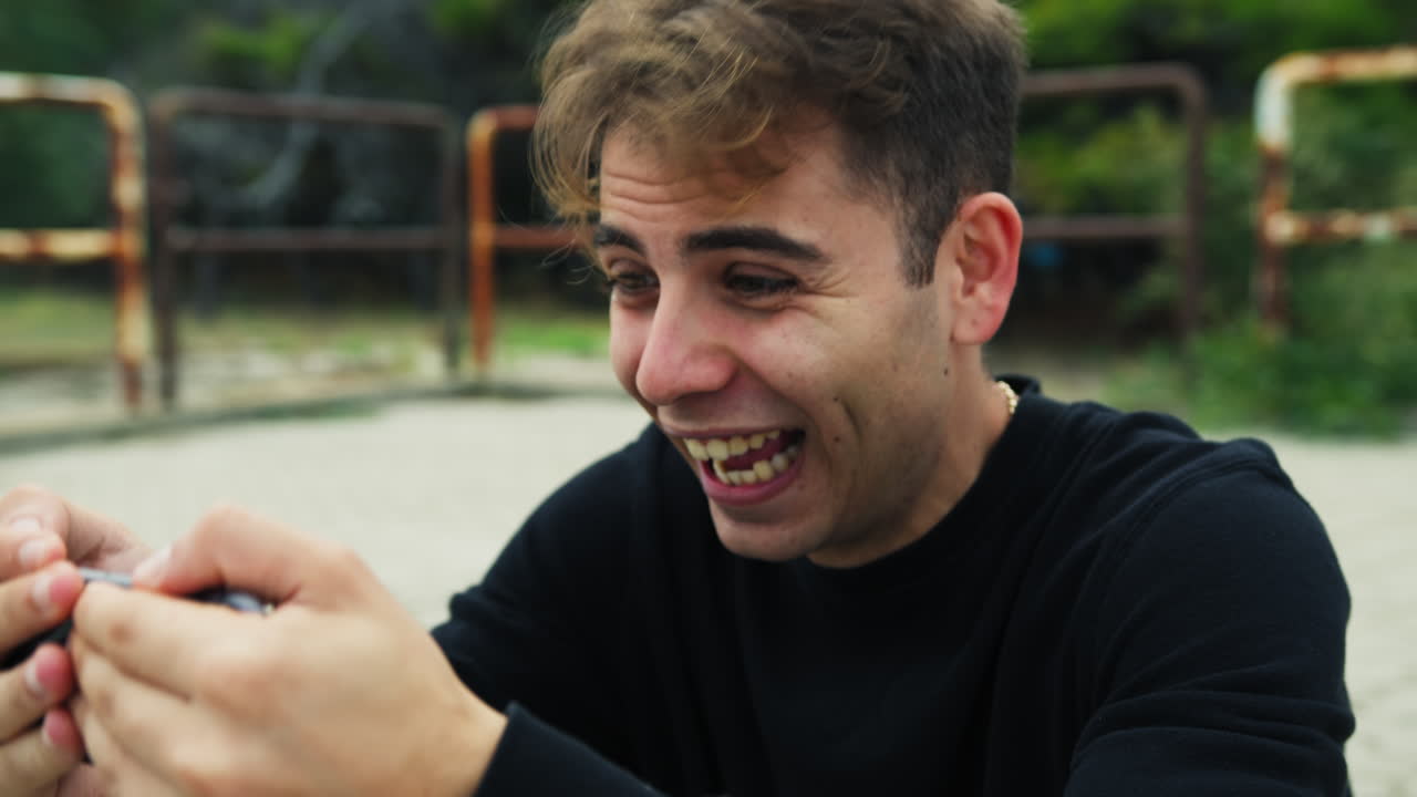 niño mira un partido de fútbol en el teléfono y reacciona exultantemente a un gol