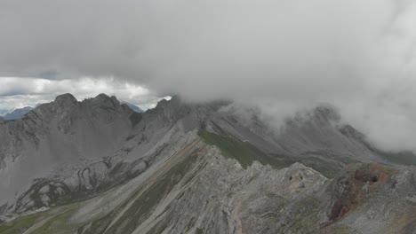 drone tracing the via ferrata federspiel ridge in the monzoni group, dolomites on a cloudy day