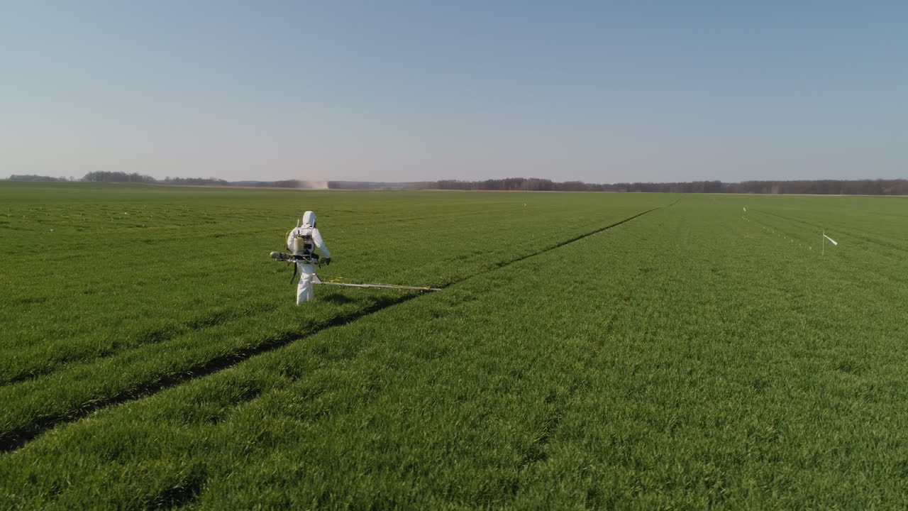Ricercatore agricolo che irrora un campo con erbicidi o pesticidi 5