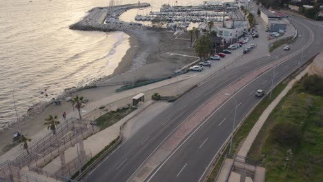 aerial-view-of-water-dock-cars-driving-by-people-walking-on-the-sidewalk-boats-parked-in-water