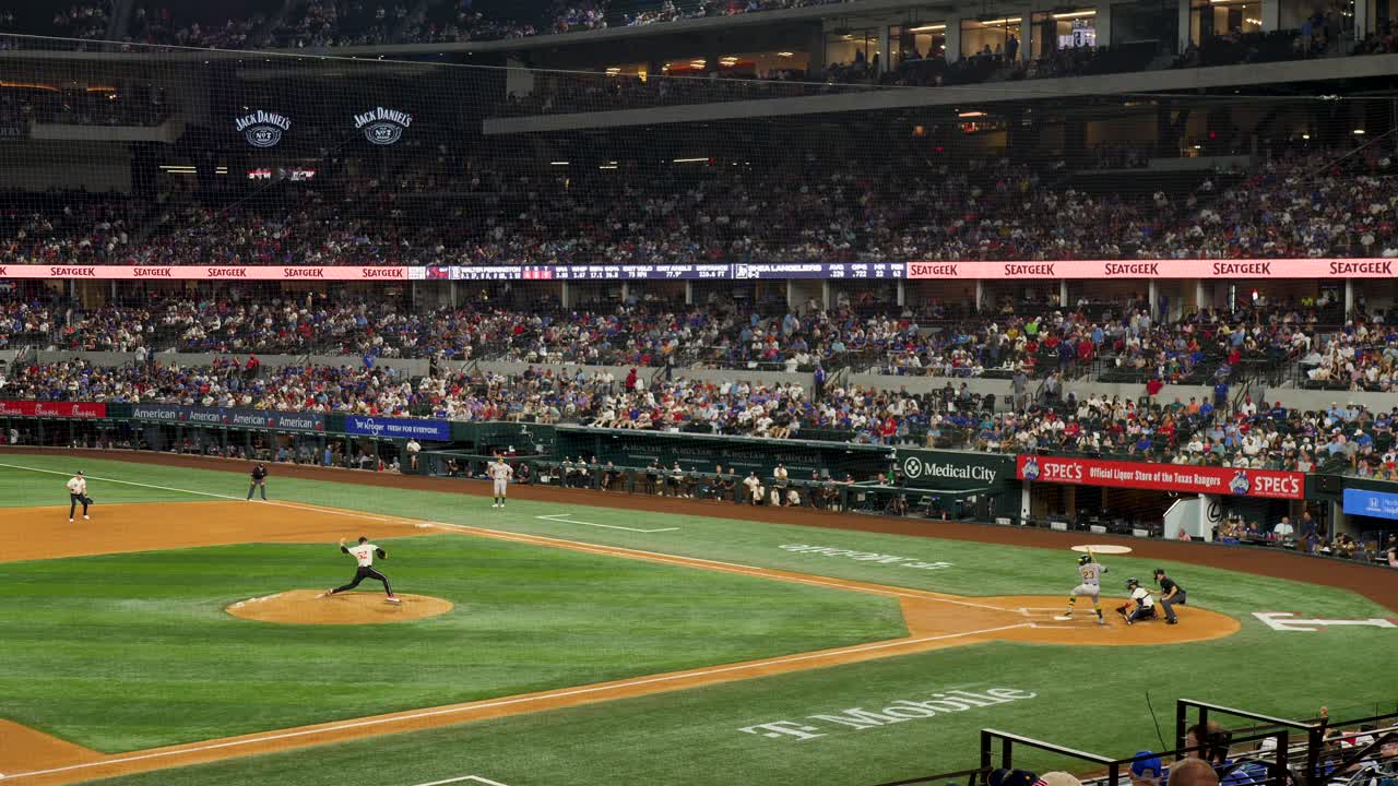 Slow motion landscape of major league baseball player hitting ball on field pitch in game match Arlington stadium Globe Life Texas USA America sports team players