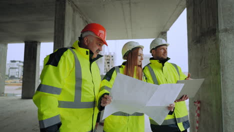 professional civil engineers are inspecting modern construction site viewing building plan in laptop