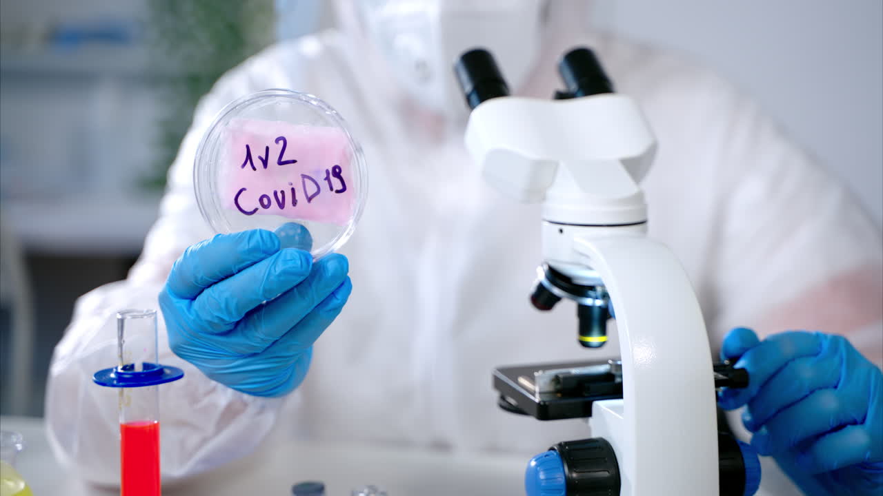 과학자가 실험실에서 코로나19 플을 분석하고 있습니다.