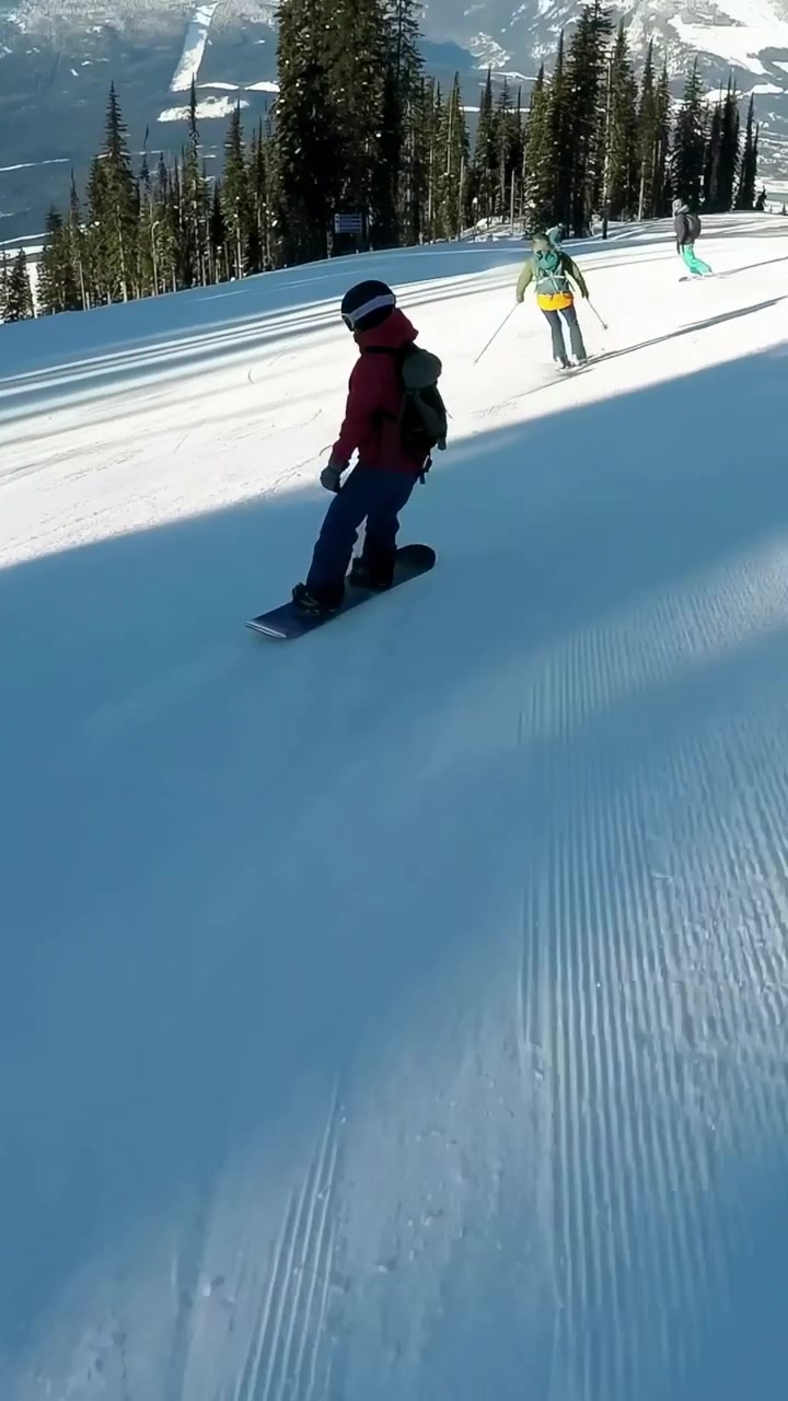 Video verticale: Snowboarder e sciatore che passano, filmano piste battute con giacca, bastoncini, spazio per il testo