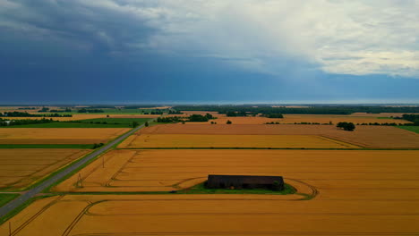 farmhouse amidst agricultural land during sunset. aerial shot