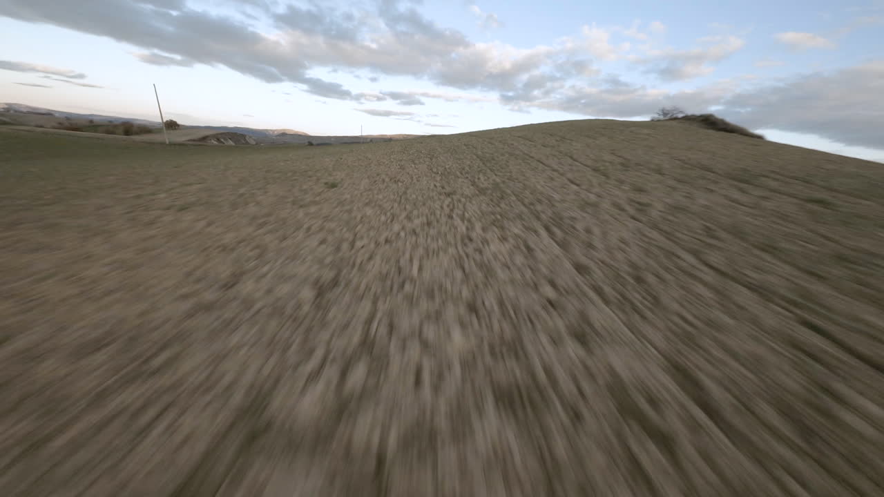 volando cerca del suelo a alta velocidad en un campo terrestre con un dron fpv