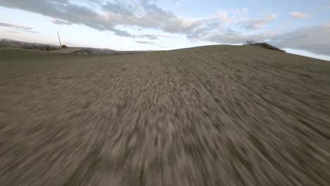 Volando-Cerca-Del-Suelo-A-Alta-Velocidad-En-Un-Campo-Terrestre-Con-Un-Dron-Fpv