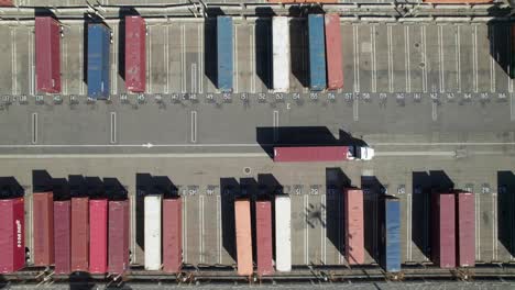 Cool-geometric-overhead-of-semi-truck-with-containers-in-industrial-shipping-yard