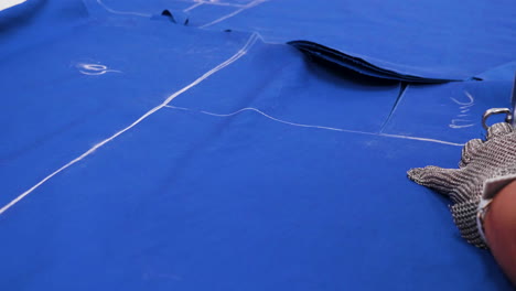 female worker cutting cloth after a pattern