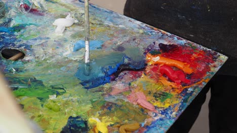 artist mixing paints on a palette