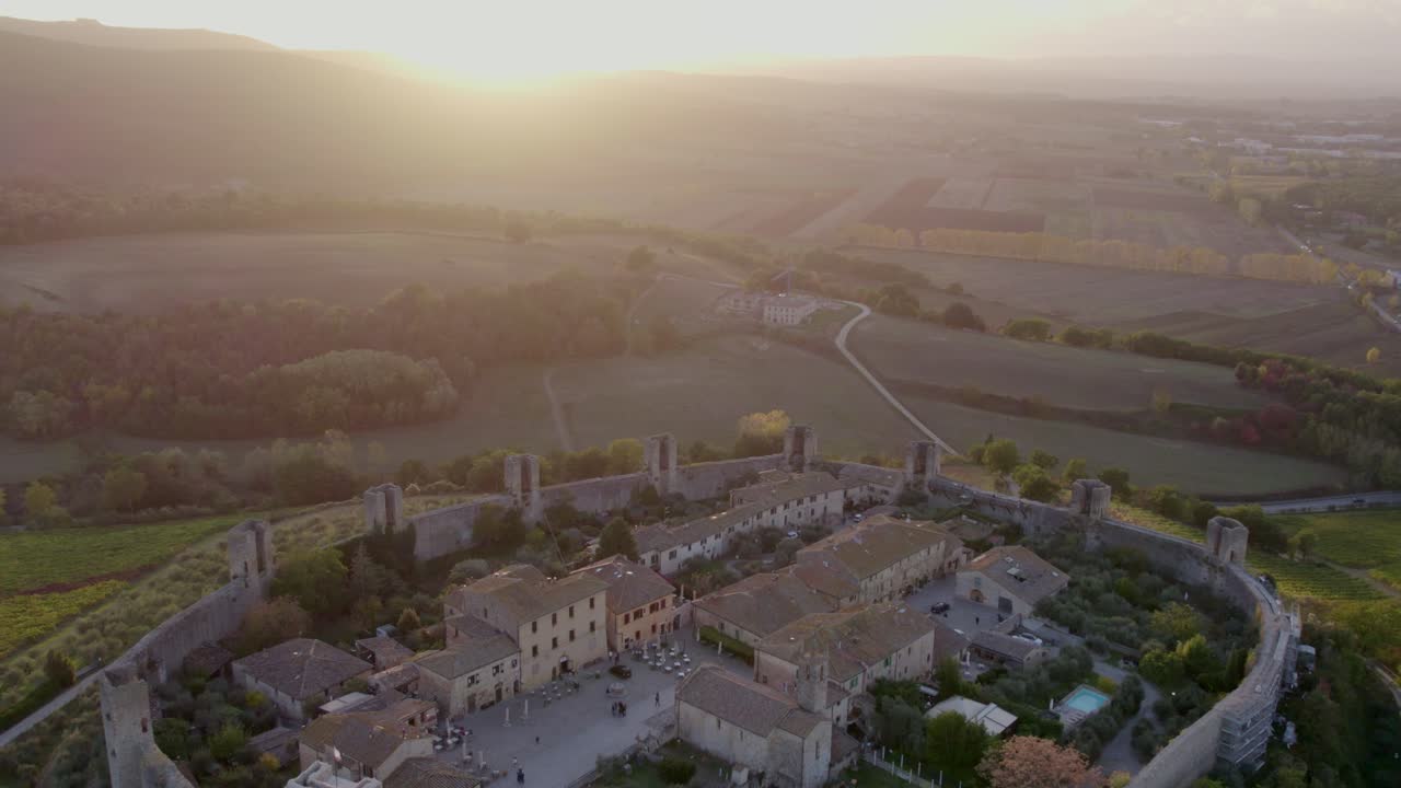 Suggestiva fortezza illuminata dal tramonto nella campagna toscana, Monteriggioni, Italia