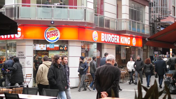 A bustling Burger King restaurant in a city street.