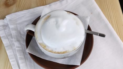 capuchino o latte. la leche espumosa se vierte en una taza redonda de café