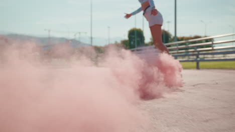 woman skateboarding with pink smoke