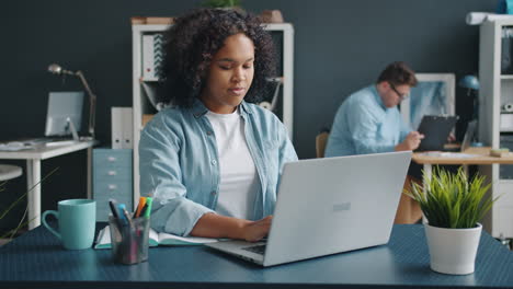 mujer trabajando en una computadora portátil en la oficina