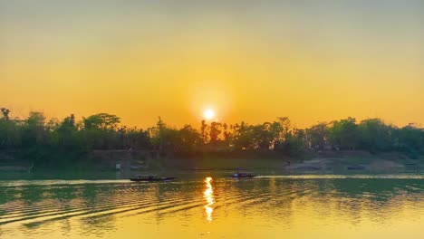 Wunderschöne-Sonnenuntergangsaufnahme-Von-Zwei-Pirogen,-Die-Den-Ruhigen-Fluss-Surma-In-Bangladesch-überqueren,-Mit-Dem-Dschungel-Im-Hintergrund