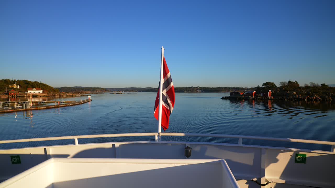 Norwegian Flag wind on ferry Boat ride wake Strömstad Stromstad Oslo Fjord Sweden Sverige Norway Norge golden hour Arctic sunlight sunset Scandinavia islands horizon Natural preserve area coastline